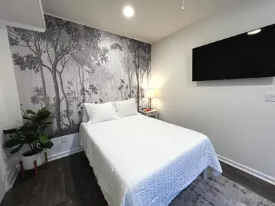 a bedroom with a bed and a tv on a wall at Private, Cozy Studio in Downtown Stamford, CT in Stamford