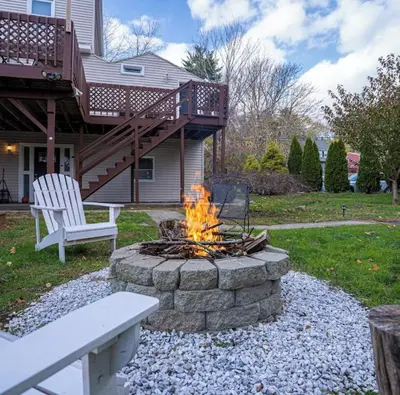 a fire pit in front of a house with a deck at Private, Cozy Studio in Downtown Stamford, CT in Stamford