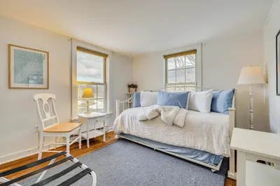 a bedroom with a bed and a chair and windows at 12 Mi to Bromley Mtn Ski Resort Quiet Hideaway in Manchester Center