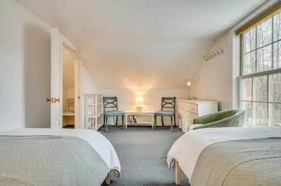 a bedroom with two beds and a desk and chairs at 12 Mi to Bromley Mtn Ski Resort Quiet Hideaway in Manchester Center