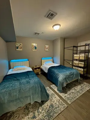 a bedroom with two beds and a rug at Modern 2BR, King Suite and Free Parking, 30min to NYC in Newark