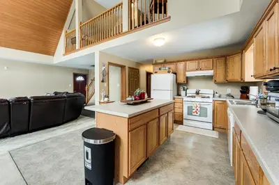a large kitchen with wooden cabinets and a staircase at Mount Vision Home for Cooperstown Baseball Fams in Mount Vision