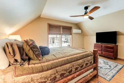 a bedroom with a bed and a flat screen tv at Mount Vision Home for Cooperstown Baseball Fams in Mount Vision