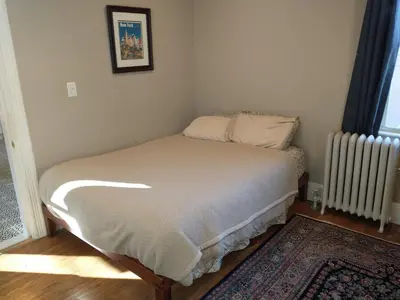 a small bedroom with a bed and a radiator at 3 Bedroom Apartment 30 Minutes to New York No Car Needed in Ridgefield Park