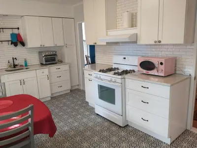 a kitchen with white cabinets and a pink microwave at 3 Bedroom Apartment 30 Minutes to New York No Car Needed in Ridgefield Park