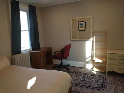 a bedroom with a bed and a chair and a window at 3 Bedroom Apartment 30 Minutes to New York No Car Needed in Ridgefield Park