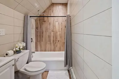 a bathroom with a toilet and a tub and a sink at Modern 2BR Near NYC with Free Parking and Workspace in East Orange