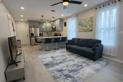 a living room with a couch and a kitchen at Bright Renovated 3BR Apartment w Private Entrance