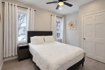 a bedroom with a bed and a ceiling fan at Bright Renovated 3BR Apartment w Private Entrance