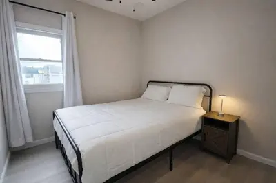 a small bedroom with a bed and a window at Bright Renovated 3BR Apartment w Private Entrance