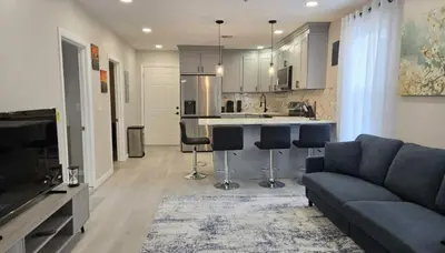 a living room with a couch and a kitchen at Bright Renovated 3BR Apartment w Private Entrance
