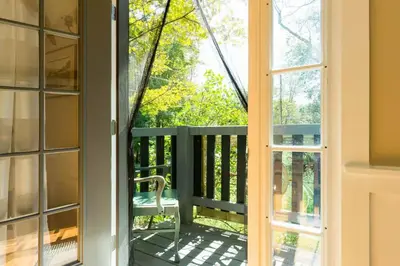a door leading to a balcony with a chair at The Arts & Crafts House with Skylights, Deck, Jetted Bathtub in Kingston
