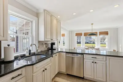 a kitchen with white cabinets and black counter tops at Minutes to Beaches - Home Theater, Couples Retreat in Milford