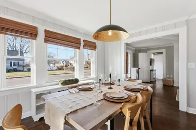 a dining room with a table and chairs and windows at Minutes to Beaches - Home Theater, Couples Retreat in Milford