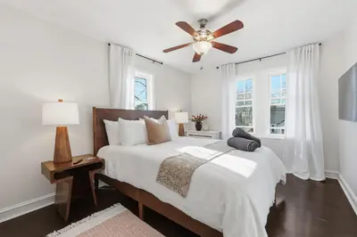 a white bedroom with a bed and a ceiling fan at Minutes to Beaches - Home Theater, Couples Retreat in Milford