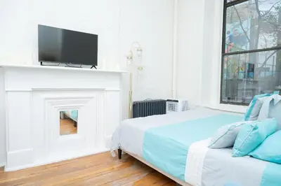 a bedroom with a bed and a tv on a fireplace at Elegant84 West Side Home 5 min to Central Park in New York
