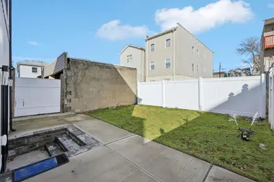 a backyard with a white fence and grass at Easy-Access & Quick to NYC, EWR, Dream Mall, Stadium in Jersey City