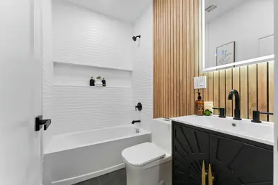 a bathroom with a tub and a toilet and a sink at Easy-Access & Quick to NYC, EWR, Dream Mall, Stadium in Jersey City
