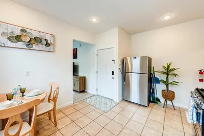 a kitchen with a stainless steel refrigerator and a table at Serene Hamilton ELM 13MI to Time Square Laundry Easy Parking in Teaneck