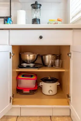 a kitchen cabinet filled with pots and pans at Serene Hamilton ELM 13MI to Time Square Laundry Easy Parking in Teaneck