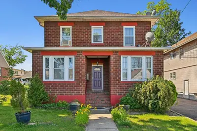 a red brick house with a blue door at Serene Hamilton ELM 13MI to Time Square Laundry Easy Parking in Teaneck