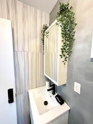 a bathroom with a white sink and a mirror at Madison Ave Oasis in New York