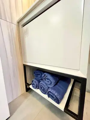 a cupboard with blue towels in a bathroom at Madison Ave Oasis in New York
