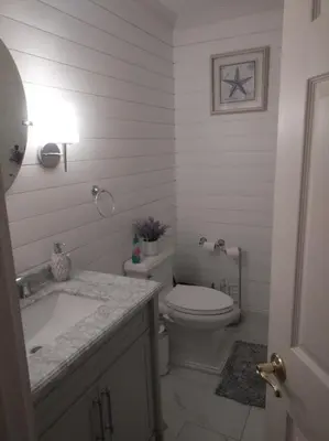 a white bathroom with a toilet and a sink at Lucious Lagrangeville in Lagrangeville