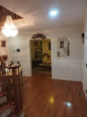 an empty living room with wooden floors and a light fixture at Lucious Lagrangeville in Lagrangeville