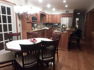 a kitchen with wooden cabinets and a table and chairs at Lucious Lagrangeville in Lagrangeville
