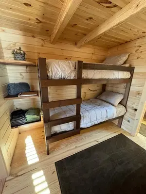 a room with two bunk beds in a log cabin at Private Luxury Log Cabin in the Endless Mountains, Firepit, Farm Charm in Kingsley