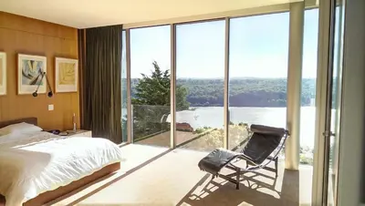 a bedroom with a bed and a chair in front of a window at Extraordinary Private Retreat Near NYC in Highland