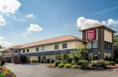 a hotel with a pink sign on the side of a building at Red Roof Inn Hartford - Vernon in Vernon