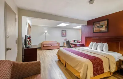 a hotel room with a bed and a chair at Red Roof Inn Hartford - Vernon in Vernon