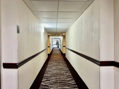 a corridor of an empty hallway in an office building at Red Roof Inn Hartford - Vernon in Vernon