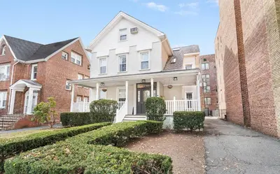 a white house with a brick wall at Montclair's Best Stays in Montclair
