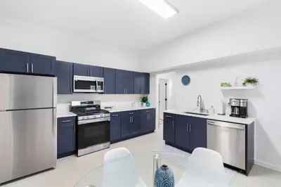 a kitchen with blue cabinets and stainless steel appliances at Montclair's Best Stays in Montclair