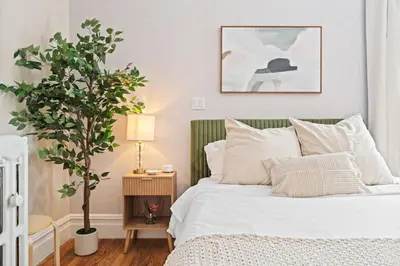 a bedroom with a white bed and a potted tree at Casa Kanso in Jersey City