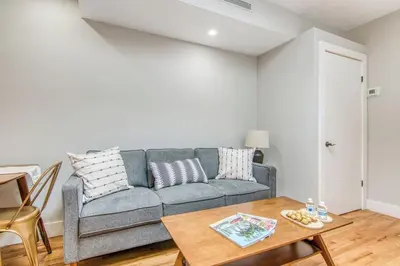 a living room with a couch and a table at Pent House on Bruckner New Luxe 2BR 2BA King Bed Fast Wi-Fi 15 Mins to Times Square in Mott Haven
