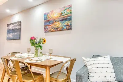 a dining room with a table and a couch at Pent House on Bruckner New Luxe 2BR 2BA King Bed Fast Wi-Fi 15 Mins to Times Square in Mott Haven