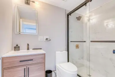 a bathroom with a shower and a toilet and a sink at Pent House on Bruckner New Luxe 2BR 2BA King Bed Fast Wi-Fi 15 Mins to Times Square in Mott Haven