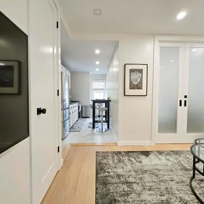 a living room with white walls and a sliding door at Bright Modern 2-bedroom apartment - Prime Astorioa - near subway in Woodside