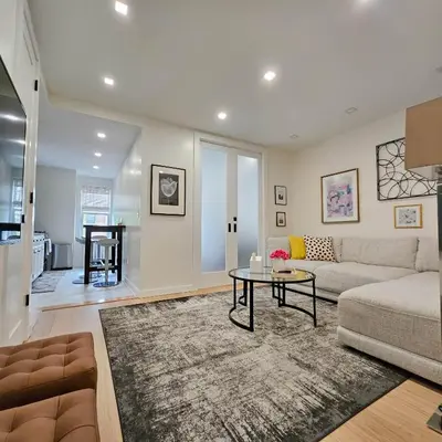 a living room with a couch and a table at Bright Modern 2-bedroom apartment - Prime Astorioa - near subway in Woodside