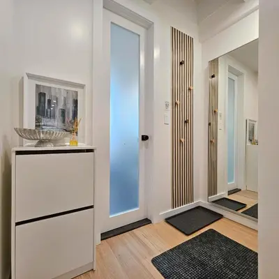 a living room with a white dresser and a mirror at Bright Modern 2-bedroom apartment - Prime Astorioa - near subway in Woodside
