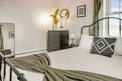 a bedroom with a bed and a dresser and a mirror at Studio in Little Italy in New Haven