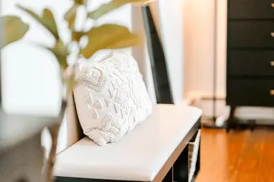 a white bench with a pillow and a vase on it at Studio in Little Italy in New Haven