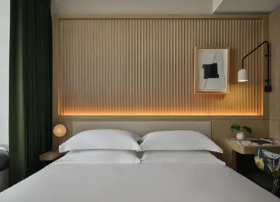 a bedroom with a large bed with white pillows at Kimpton Era Midtown New York by IHG in New York