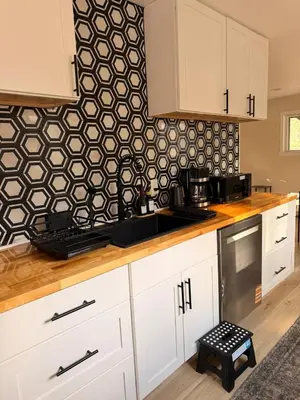 a kitchen with white cabinets and a black and white wallpaper at Modern 3-Bedroom Retreat with Fire Pit - Ski at Big Bear - Mountain Views in Eldred