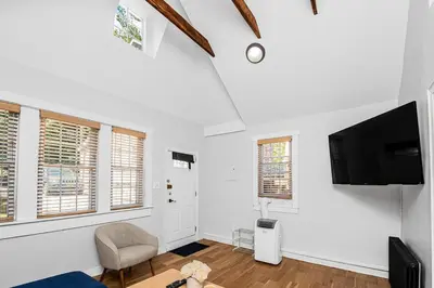 a living room with a tv and a chair at Cozy cottage close to NYC in Yonkers
