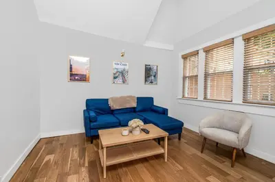 a living room with a blue couch and a chair at Cozy cottage close to NYC in Yonkers